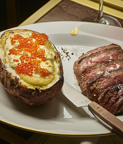 Plate of steak and baked potato with caviar topping from Don's Prime