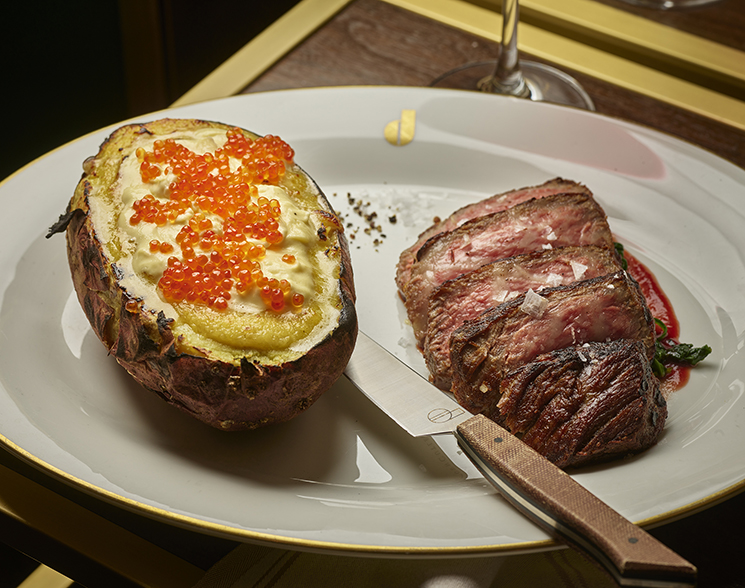 Plate of steak and baked potato with caviar topping from Don's Prime