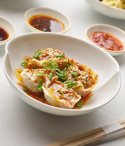 Bowl of dumplings with dipping sauces