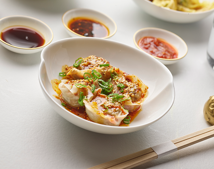 Bowl of dumplings with dipping sauces