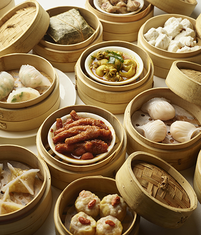 Table of dim sum baskets filled with a variety of food.