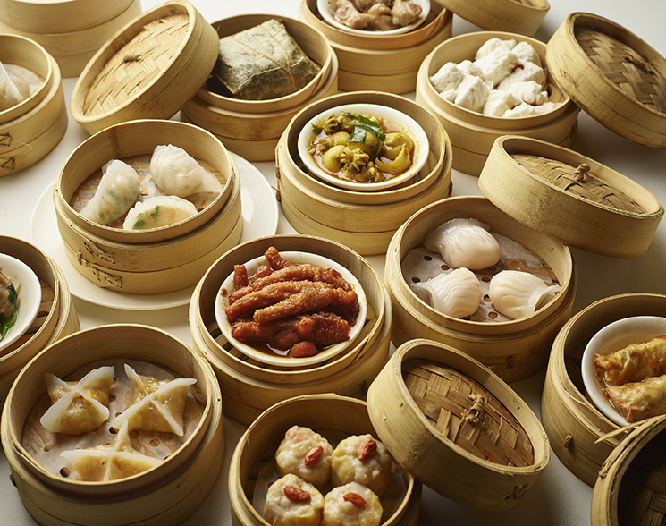 Table of dim sum baskets filled with a variety of food.