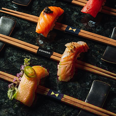 Pieces of sushi sitting on chopsticks