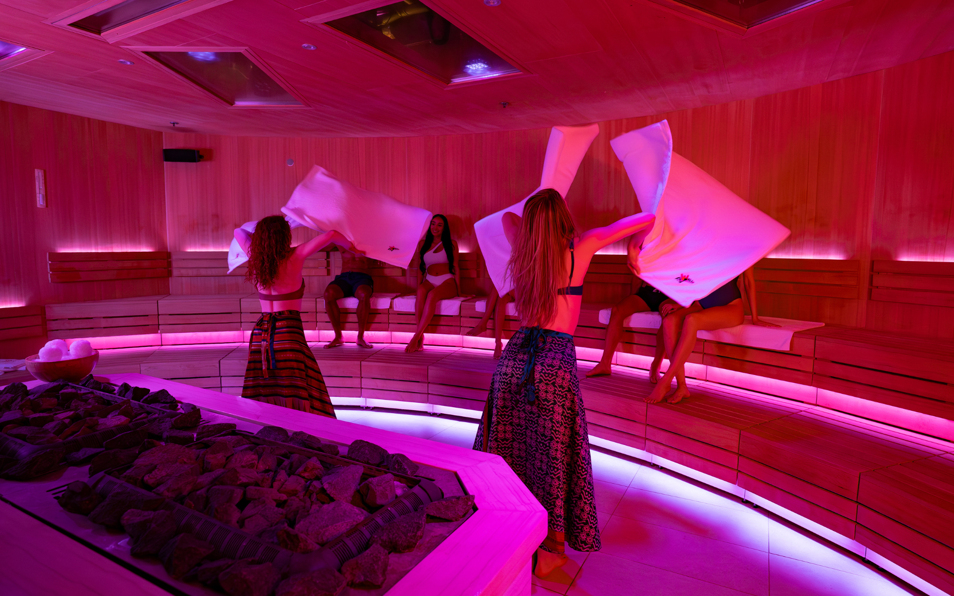 2 performers with towels in front of a seated audience