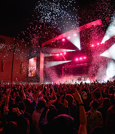 Crowded theater lit from a performance with confetti