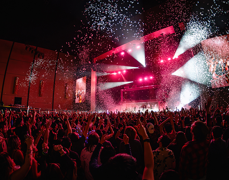 Crowded theater lit from a performance with confetti