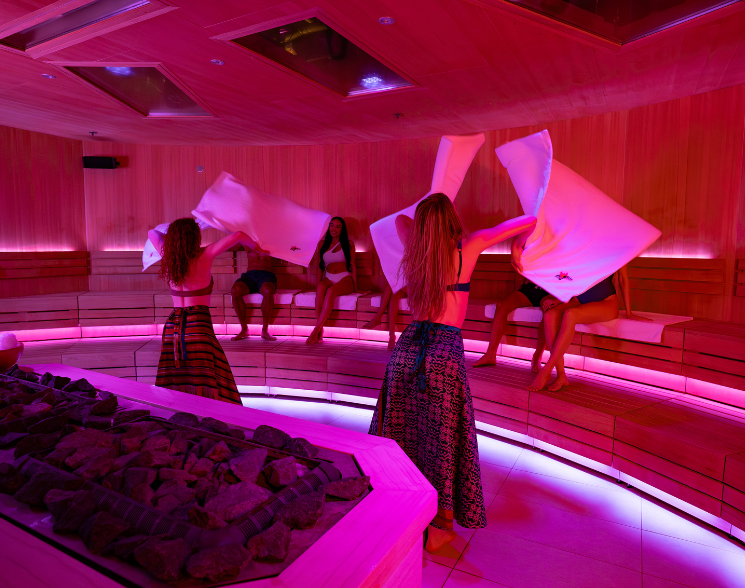 2 performers with towels in front of a seated audience