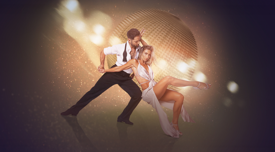 Pair of dancers posing in front of disco ball