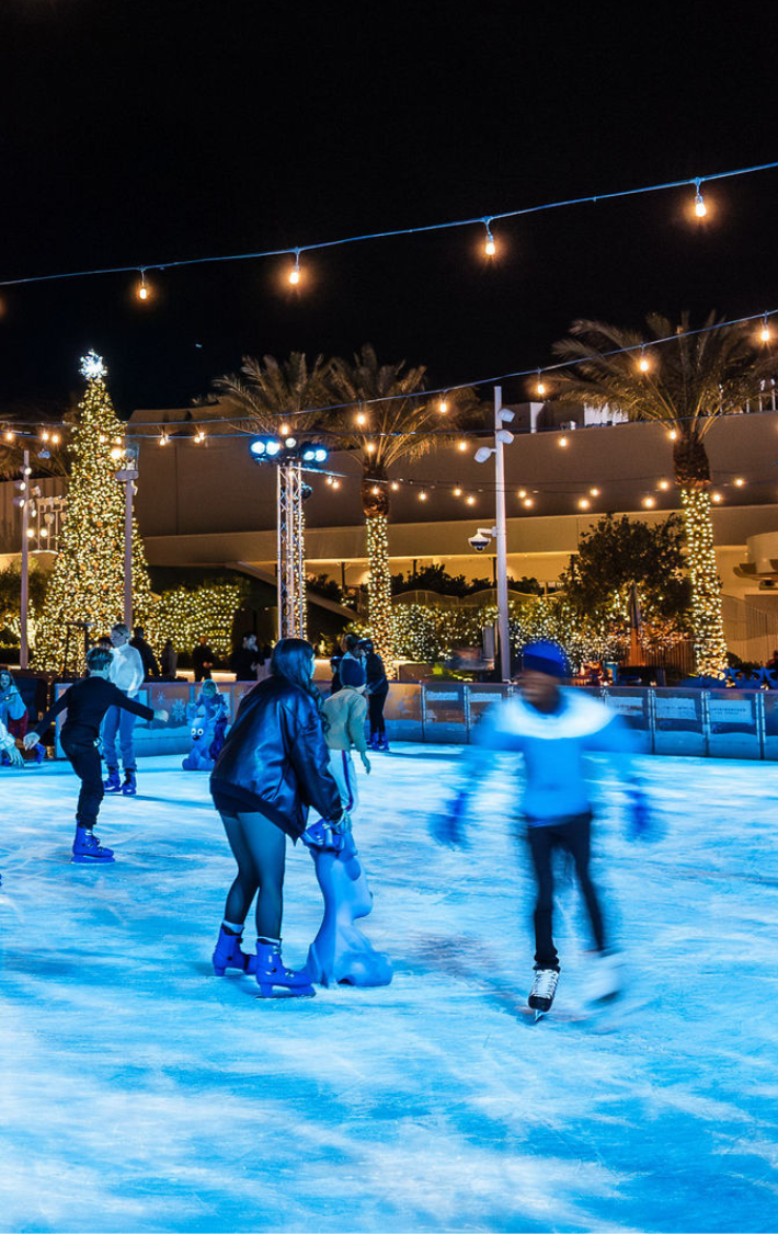 Ice skaters under holiday lights
