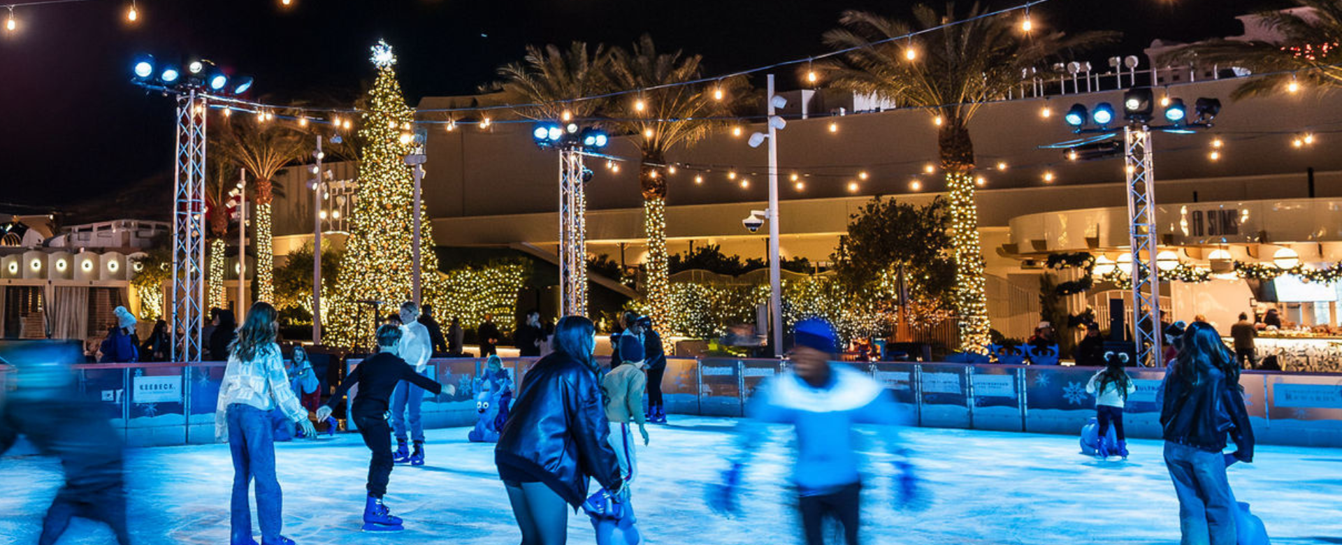 Ice skaters under holiday lights