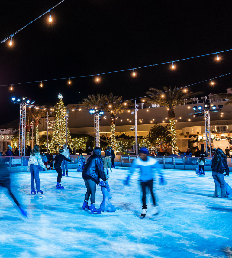 Ice skaters under holiday lights