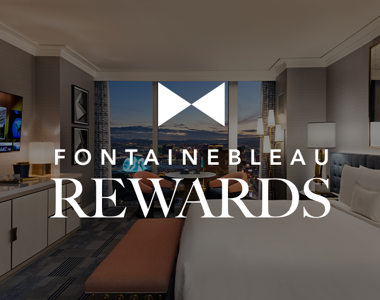 Bed and seating area under text: Fontainebleau Rewards
