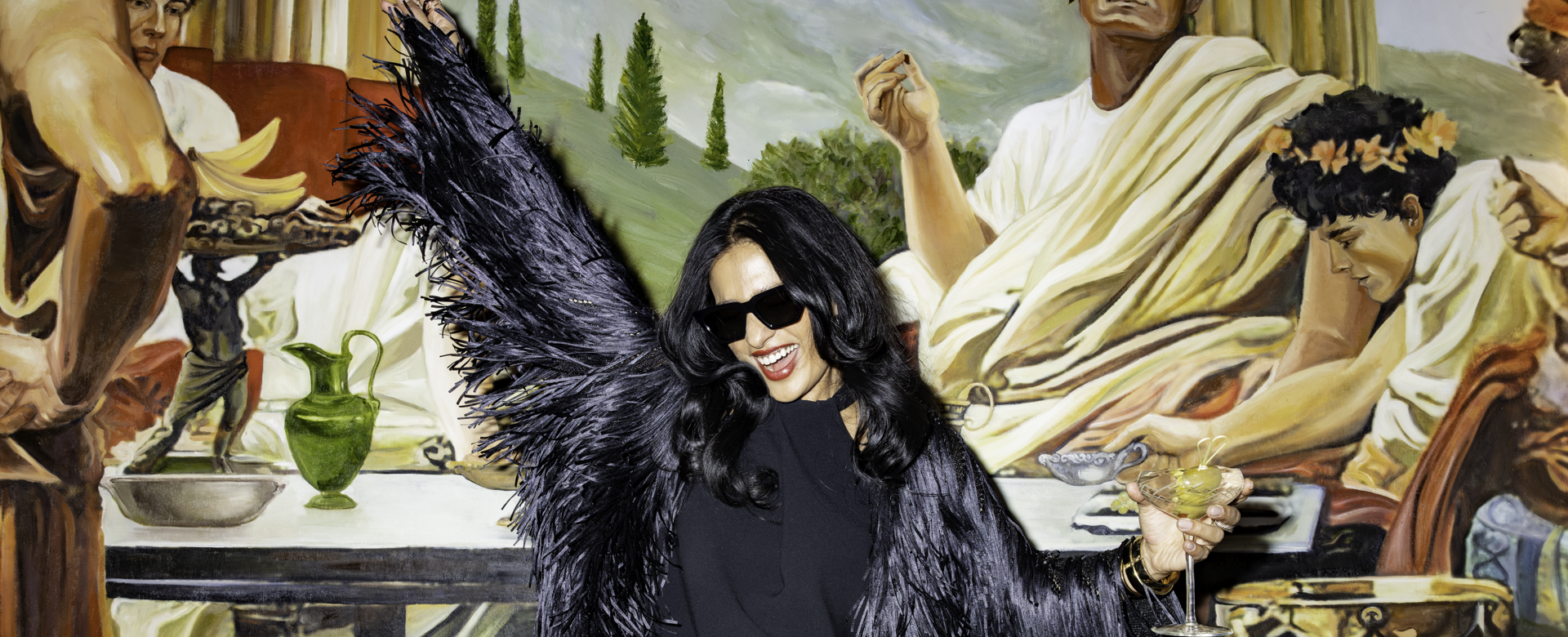 Woman raising arm up in sunglasses smiling holding a cup