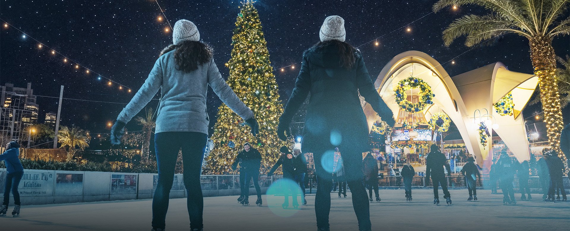 People on ice skates looking at a holiday tree