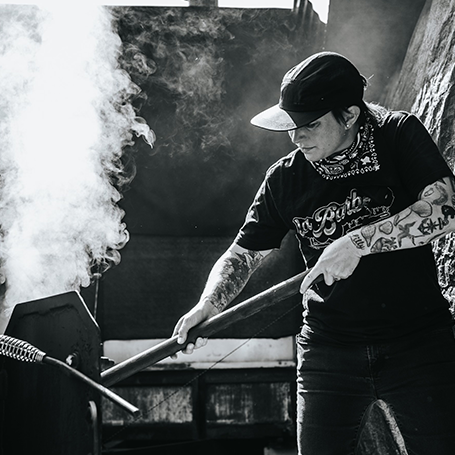Pitmaster stoking a fire in black and white