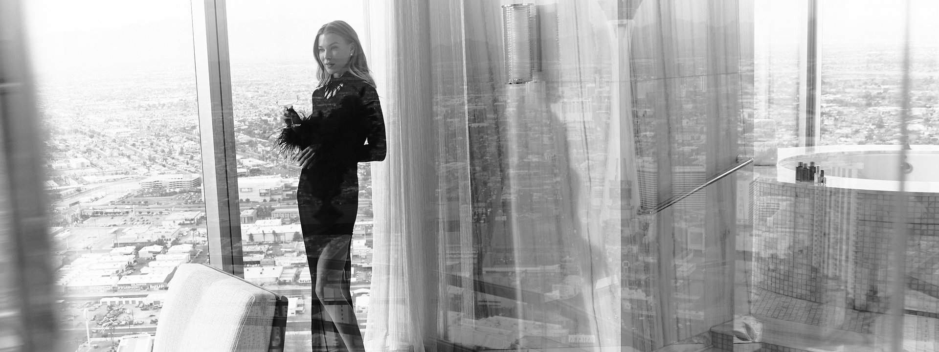 Model in black dress in front of window with black box and white text: No Resort Fees