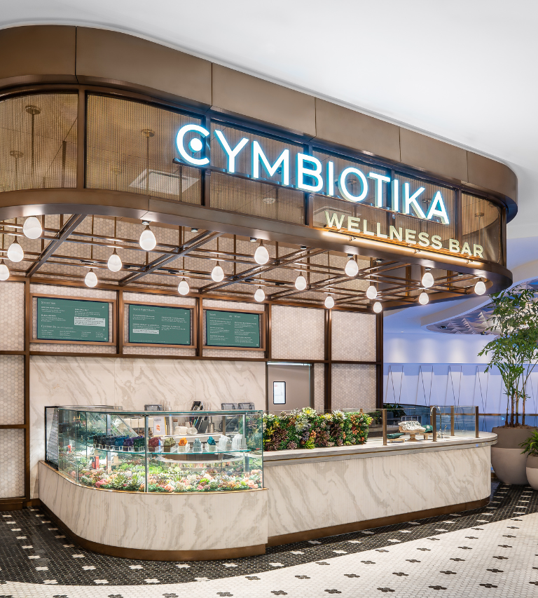 Cymbiotika Wellness Bar neon sign and food counter