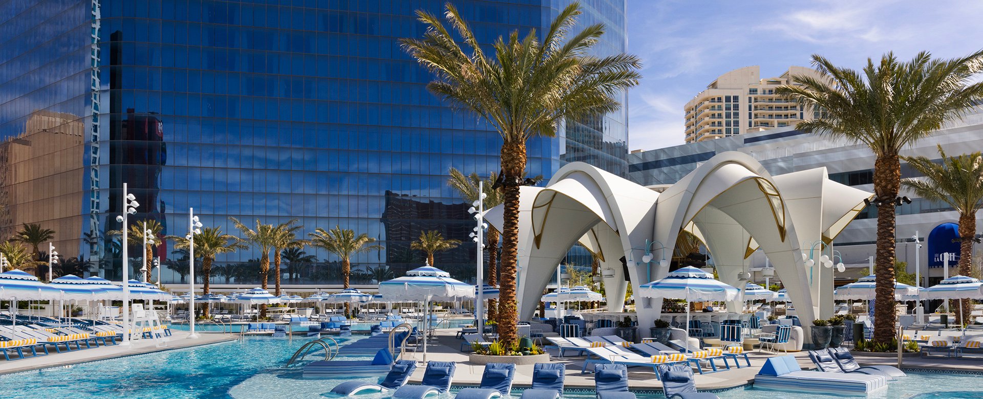 Poolside scene with lounges on the shallow shelf in the pool near the white overhang of Bleau Isle