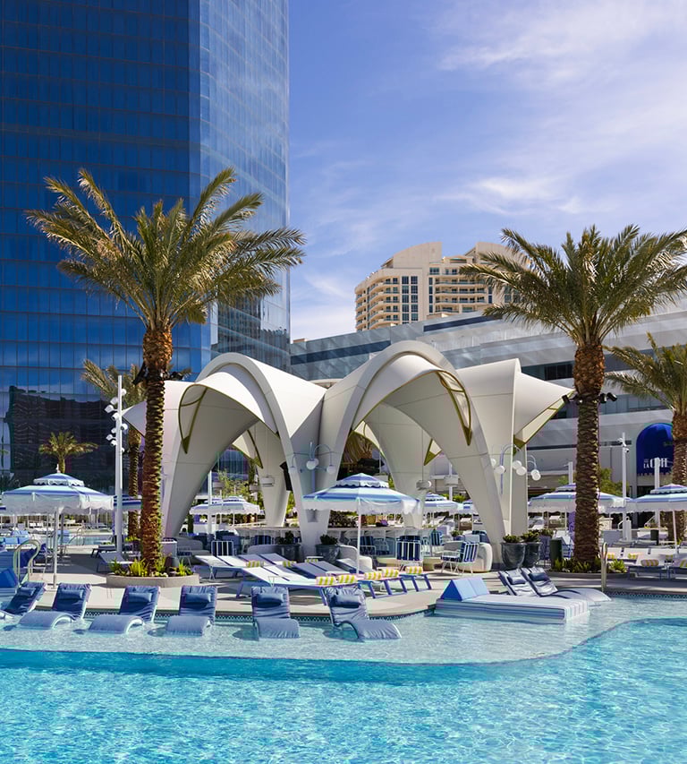 Poolside scene with lounges on the shallow shelf in the pool near the white overhang of Bleau Isle