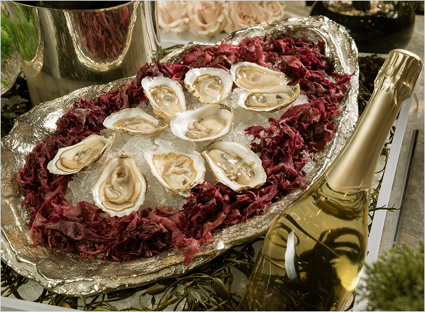 Oysters on ice with decor and champagne bottle