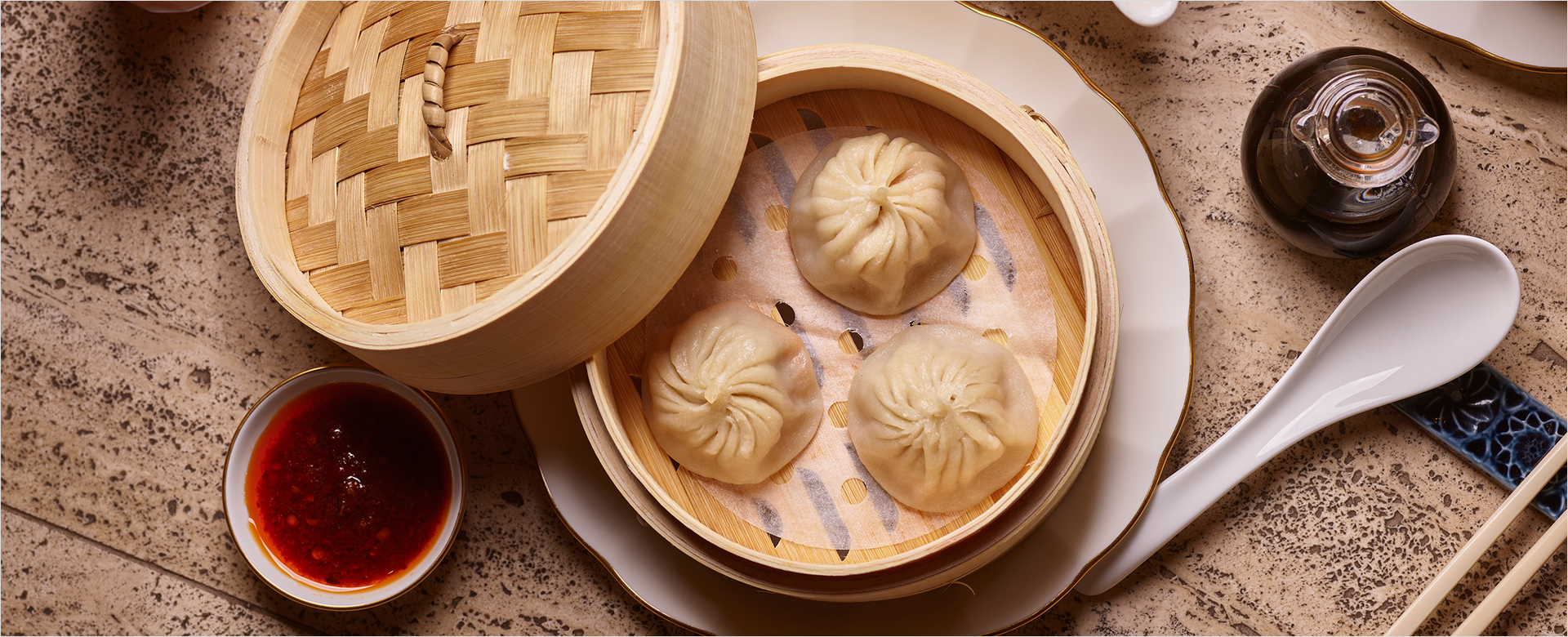 Dumplings in container with sauce and settings