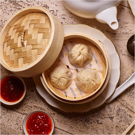 Dumplings in container with sauce and settings