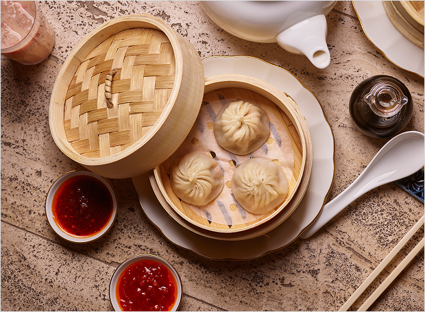 Dumplings in container with sauce and settings