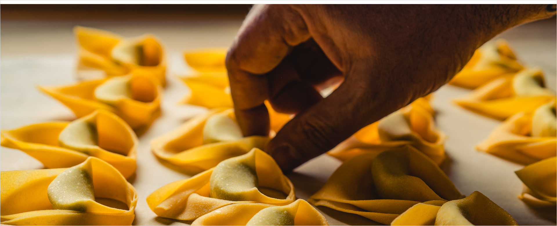 Hands forming pasta shapes