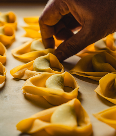 Hands forming pasta shapes