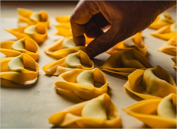 Hands forming pasta shapes