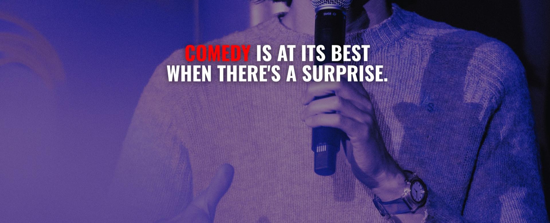 Comedian holding a microphone under purple stage lighting with text reading, “Comedy is at its best when there’s a surprise.