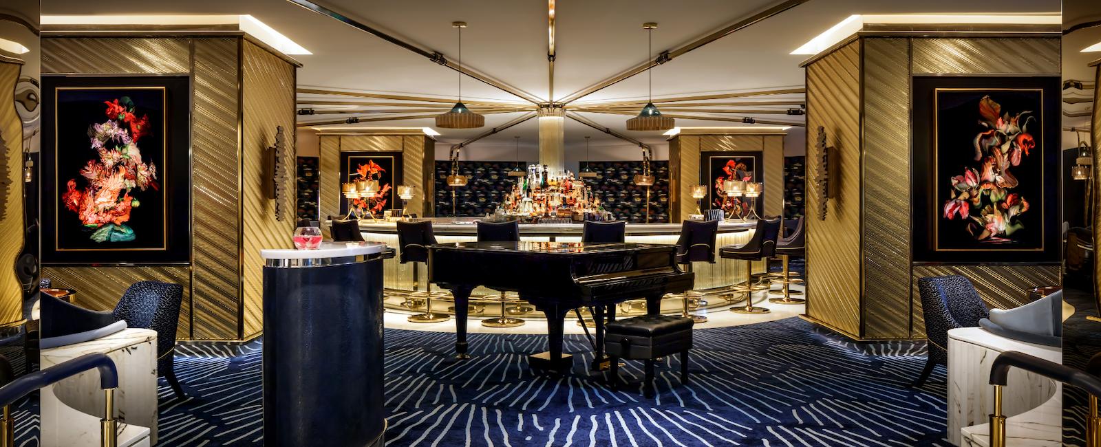 Collins cocktail lounge with lobby bar, grand piano for live entertainment on select evenings, beautiful artwork, gold accents, plush blue carpeting and marble decor